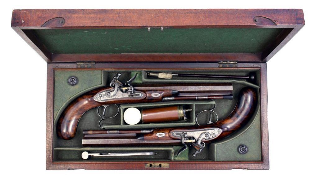 Figure 3 A cased pair of half-stocked flintlock duelling pistols with octagonal 22 bore barrels signed Sykes, Oxford in gold and struck with Irish registration marks DC 4909 & 4910 for Dublin City,