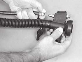 Remove the inflator hose from the power inflator body by gripping the grooved sleeve over the quick disconnect coupling with your thumb and forefinger