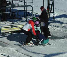Sit skis need to be put in the loading position before entering the loading area. In some cases this may mean that the student needs extra support to balance when they enter the loading area.