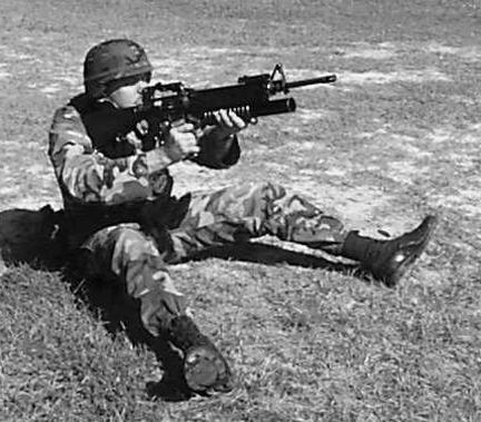 Pull the weapon down slightly with your left hand and pull it to the rear firmly with your right hand. Figure 5-5. Sitting position, open-legged, quadrant sight.