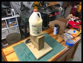 placed a piece of mdf to even out the weight on the board. Then a heavy block and gallon of glue. Hopefully as the wet fibers expand back the board will flatten out.