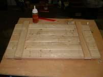 2. Place all five pieces of the top side by side, keeping the two ripped boards at each end. Take two of the 1x2x12 9/16 inch pieces and nail to the tope boards 2 ¼ inches from each end. 3.