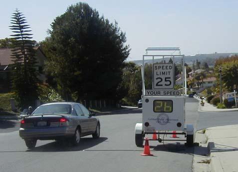 Radar Trailer Phase 1 A portable trailer equipped with a radar unit that detects and displays the speed of passing vehicles on a reader board located next to a speed limit sign.