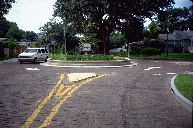 Level 2 Limited Application Roundabout Description: Circular raised island, about 10-70 in diameter, with Yield on entry and deflector islands; the traffic flows around in a counter-clockwise