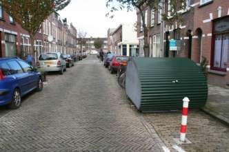 A cycle drum on the parking lane in a residential street, with a bollard protecting access. Utrecht, NL 2 Cycle drum with transparent, light design.