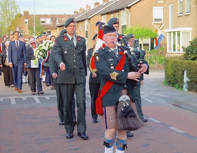 Pipe Major Swan leads the Remembrance Day delegation to the Private Strang Monument.