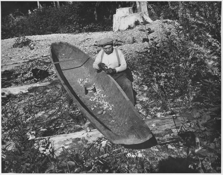 6. Quinault man using plane to smooth side of canoe near Lake Quinault, Washington Source :