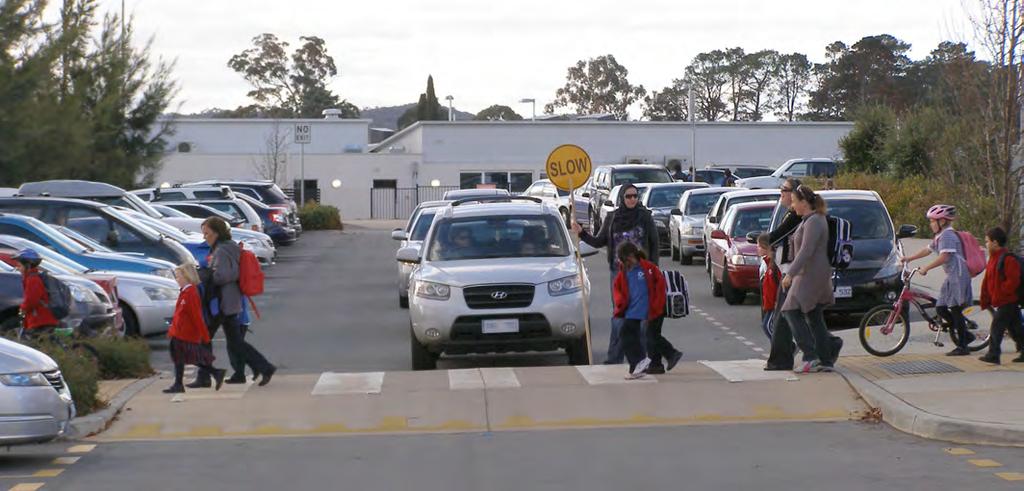 Photo 16 (above): To achieve safe and efficient traffic flow in large off-street school parking areas, some schools, like Harrison School in this picture, use trained volunteers at key points on