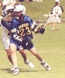 Men s lacrosse begins with a face-off. The ball is placed between the sticks of two squatting players at the center of the field. The official blows the whistle to begin play.