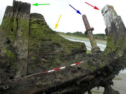 Figure 9 A photograph showing the sternpost (red arrow), the rudder stock (blue arrow), the inner-post (green arrow) and the knee (yellow arrow) (looking west) Figure 10 The rudder stock extends from