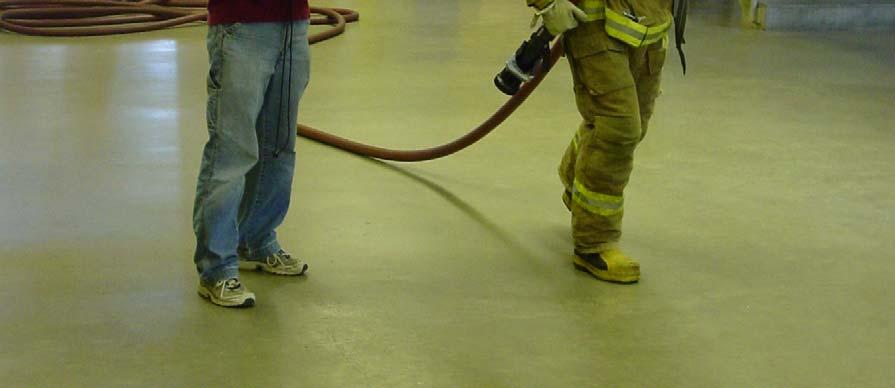 With the nozzle and hose held securely over the preferred shoulder, the applicant advances the hose from the start line to the finish line.