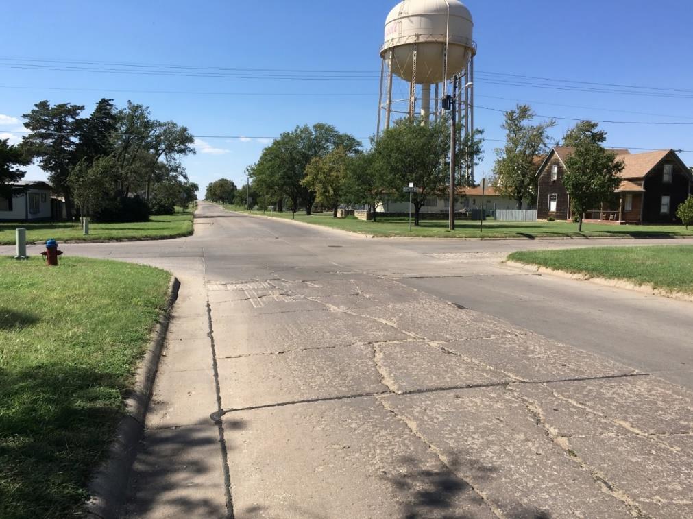 This stretch currently only has sidewalk from Maple Street to Fossil Street and is in very poor condition. The street is currently concrete and badly cracked.