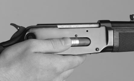 FIGURE 9 FIGURE 10 Insert the shell through the loading port Working the finger lever Loading a shell from the magazine position, press the spring cover inward with the crimp end of the first shell