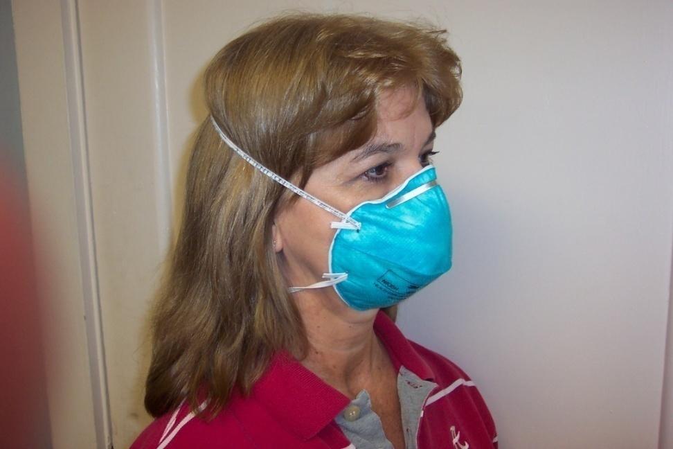 A properly donned N95respirator The respirator must be correctly oriented on the face and held in position with both straps.