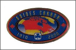 Oval, red, cotton; text Guides Canada 1910 2000 in white stitching on blue inner oval, Trefoil in blue and