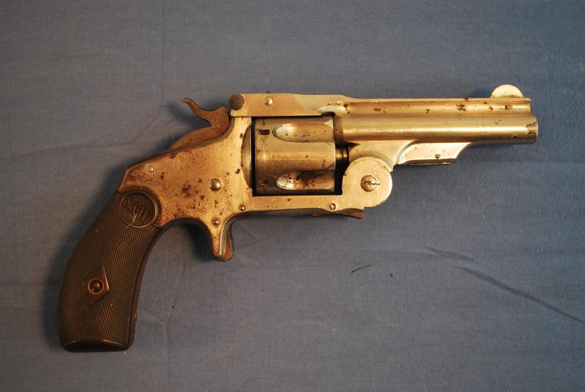 This revolver shows a mottled brown patina over most of its surface, with very few spots of bright blue finish and case hardening remaining.