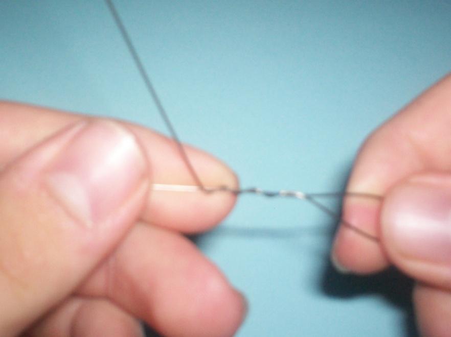 Step 3: After about a half-dozen twists, begin a series of barrel wraps by first bending the tag end of the wire at a 90-degree angle to the twists.
