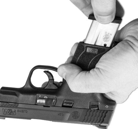 and outside the trigger guard, grasp the serrated sides of the slide from the rear with the thumb and fingers (FIGURE 29) while holding the firearm in an upright