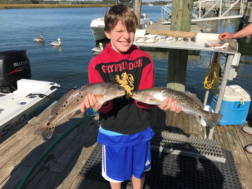 While inshore fishing with Captain Garrett Ross of Miss Judy Charters Larkham Reidlinger age 9 scored big time. He is holding and red fish and spotted sea trout.