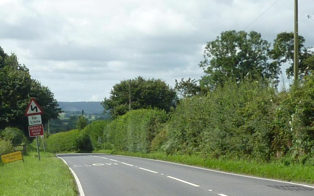 With the present location, the driver is part of the way through a series of bends, the nearside sign is hidden in the hedge and cannot be seen and the other side