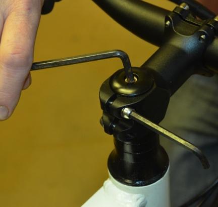The vertical bolt that screws down into the top of the headset, when tightened, will grip and pull together tightly the entire headset assembly including the bearings.