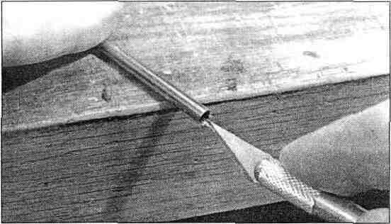 Use a hobby knife to sharpen one end of a piece of 3/16" (outside diameter) brass tubing, then use this tubing to cut the pushrod exit holes (you may use a 3/16" drill bit, but the brass tube method