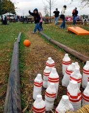 Title: Pumpkin bowling Items needed Example How to play: Using a mini pumpkin (real or fake) to roll down an alley of hay and knock down the 6 gourds at the end of the lane.