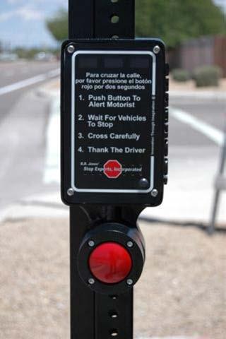 pedestrian instruction sign with the legend PUSH BUTTON TO TURN ON