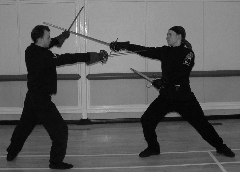 Do not cross the weapons and then raise them. The parry in prima is made with the right hand above the right shoulder.