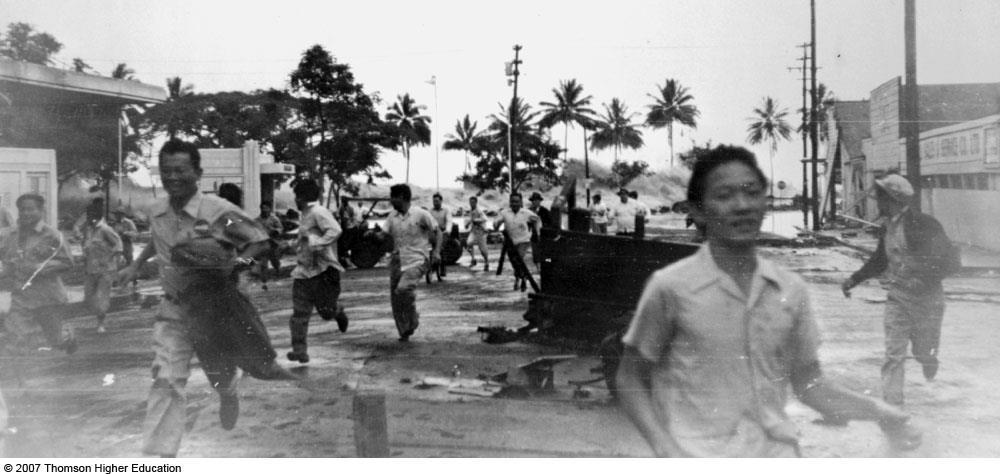 Figure 10.35: The largest wave of the 1 April 1946 tsunami rushes ashore in Hilo. Terrified residents run for their lives; more than 150 died.