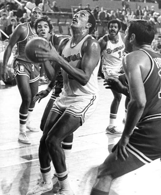Forward George Wilson goes up for a shot against AW Holt of the Chicago Bulls while Fred Crawford of the Braves looks on.