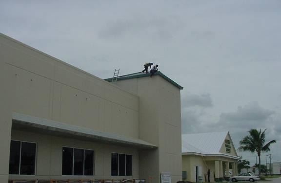 Fall Hazards in Construction Workers are installing a new metal roof without fall