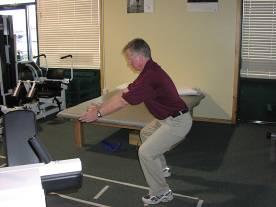 golf swing. Begin in a standing position with your feet shoulder width apart.