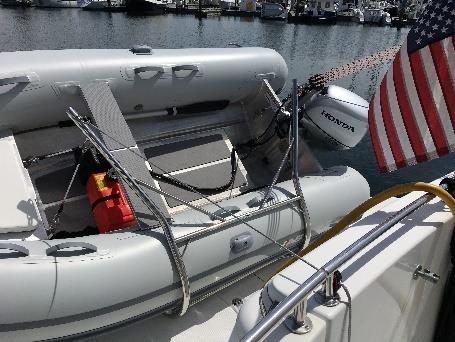 Continue hoisting until Dingy is in the storage position as shown. Reattach transom davit cables.. Remove pulley from port side bridge position and reattach at the transom position.