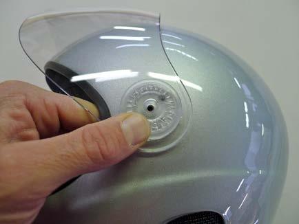 Holding the washer firmly pressed against the visor, insert the projections on the washer into the two non-threaded