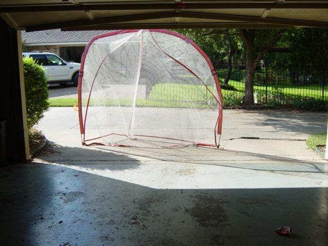 outdoor rink). Note this is a Wilson baseball backstop, available at Oshman s and most sporting goods stores, tied to the downspout so it will not move when the pucks are shot into it.