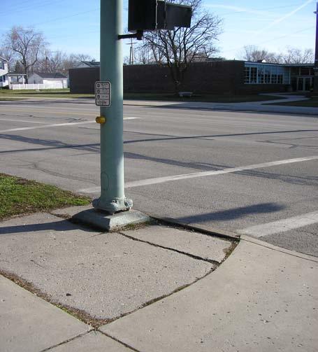 The photo of the street crossing on the left has one compliant curb ramp on