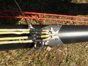 Find the trapeze wires and attach them in the upper hole of the mast hound with