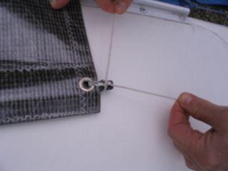 Fold the batten tie line in half and loop through the grommet on 1 side of the sail. Lead both lines then through the hole in the batten and then through the grommet on the other side.
