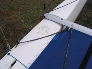The ends of the spin sheet can be tied together at one of the rear tramp grommets, or they can be lead across to opposite sides of the boat to a point just forward of the skipper seating position.
