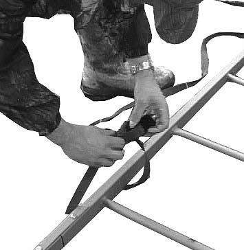 The seat on the Single Shot ladder stand is removable. Wrap the webbing over the frame and buckle as shown in Figure 24. The back of the seat has a flexible snap that can be secured over the frame.