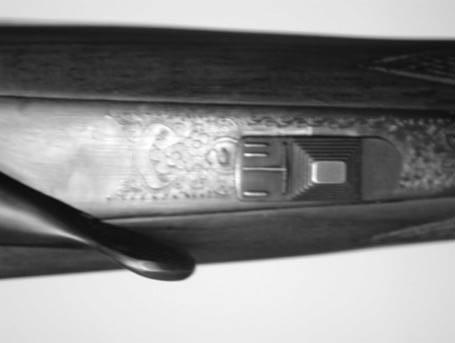 MANUAL SAFETY OPERATION The manual safety on Weatherby Side-By-Side shotgun is a dual-action slide-type safety located on the receiver tang behind the top lever.