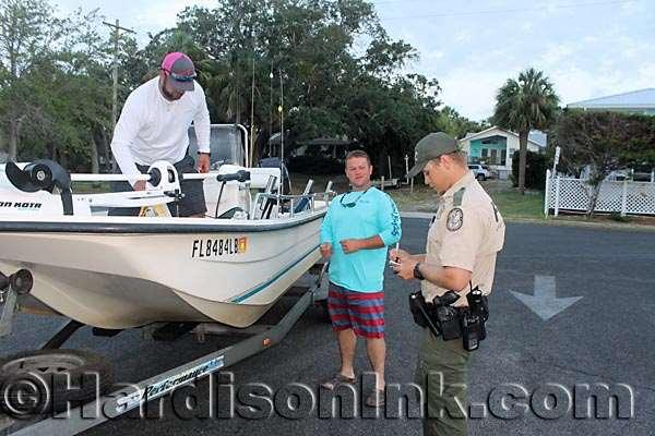 FWC saves lives and conserves natural resources Justin Geiger (aboard the boat) and Adam Hayes help an FWC officer check out their material for safety before they depart to be in the Chiefland Rotary