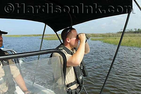 FWC Officer James Fox looks through binoculars to