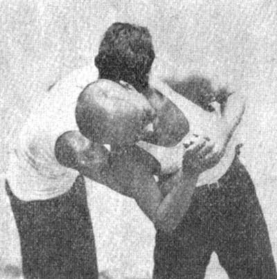 right (left) elbow over the right (left) arm of the enemy and presses the arm of the enemy to his side under the armpit with it.