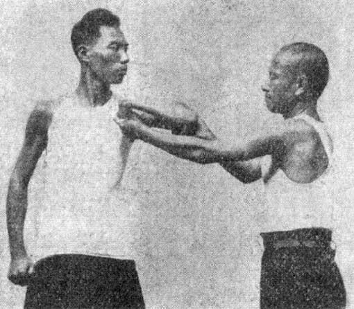 Photo 75 - Clutching a wrist, second phase. At the same time A(B) pushes the enemy s elbow from himself with the right (left) arm.