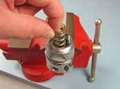 Using the modified screwdriver, turn the adjustment screw until it is flush with the top of the spring