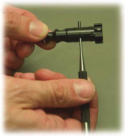 Remove extractor pin by pushing it out with the p of the firing pin or a punch.