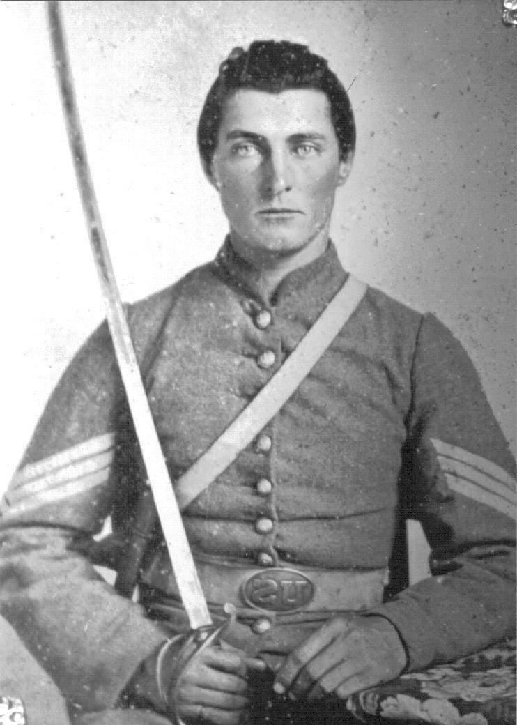 A Sgt. of the 1 st NC wearing a gray frock coat and buff saber belt.