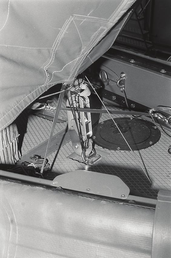 Pull the suspension slings through the holes provided and raise them temporarily. Tie a loop of ½-inch tubular nylon to each sail car tie-down in the forward cockpit.